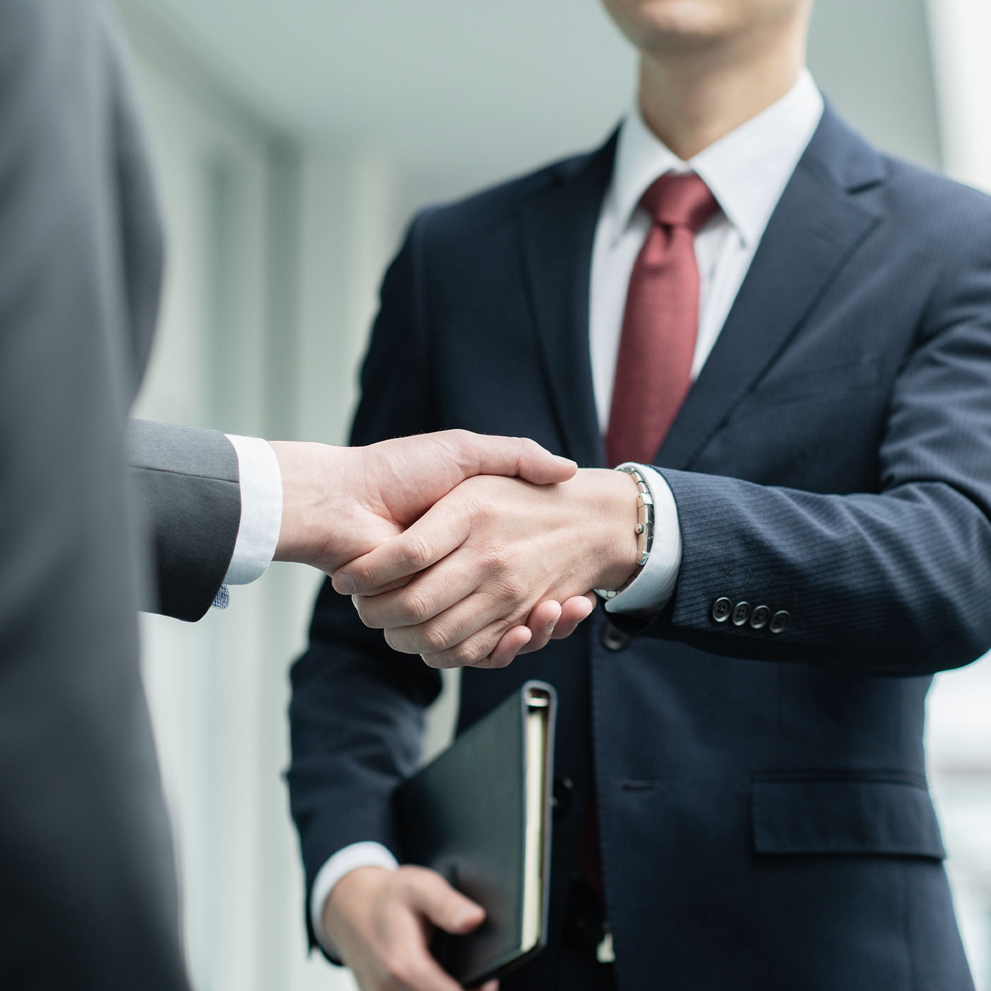 事業会社とスタートアップ等の企業が握手をしているイメージ